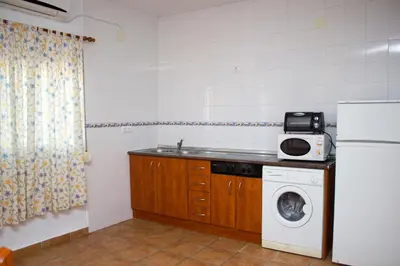 a kitchen with a washing machine and a refrigerator at Villa Juan in Conil de la Frontera