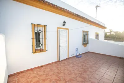 a white house with a tile floor and a door at Villa Juan in Conil de la Frontera