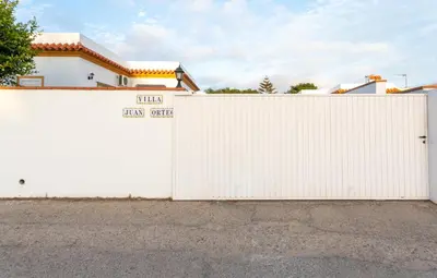 a white fence in front of a house at Villa Juan in Conil de la Frontera