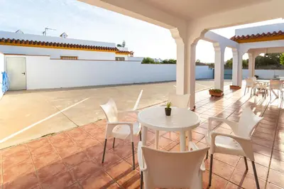 a patio with a table and chairs on a roof at Villa Juan in Conil de la Frontera