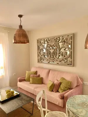 a living room with a pink couch and a table at Hidden Gem Playa Helios con Ascensor & Parking in Cádiz