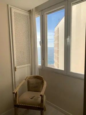 a chair sitting in a room with a window at Hidden Gem Playa Helios con Ascensor & Parking in Cádiz