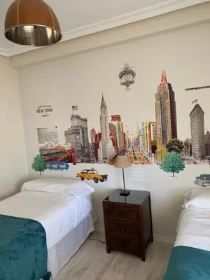 a bedroom with two beds and a city mural on the wall at Hidden Gem Playa Helios con Ascensor & Parking in Cádiz