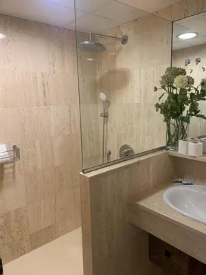 a bathroom with a sink and a glass shower at Hidden Gem Playa Helios con Ascensor & Parking in Cádiz