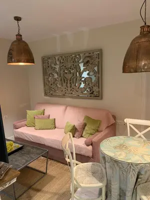 a living room with a pink couch and a table at Hidden Gem Playa Helios con Ascensor & Parking in Cádiz