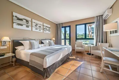 a hotel room with a bed and a desk at Barceló Jerez Montecastillo & Convention Center in Jerez de la Frontera