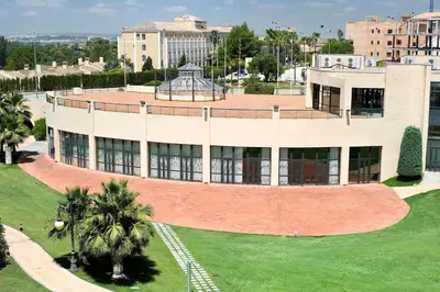 an aerial view of a building with palm trees in front at Barceló Jerez Montecastillo & Convention Center in Jerez de la Frontera