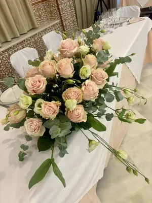 a white table with a bouquet of pink roses at Hotel Chipiona in Chipiona