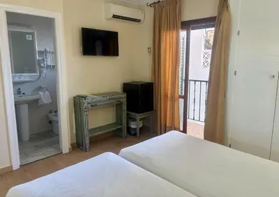 a bedroom with a bed and a bathroom with a television at Hotel Chipiona in Chipiona