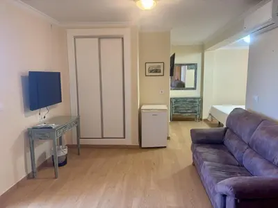 a living room with a couch and a table and a television at Hotel Chipiona in Chipiona