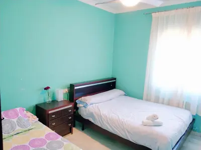 a bedroom with blue walls and a bed and a window at VillaLaJaraCom CHALET CON PISCINA, PROHIBIDAS DESPEDIDAS GRUPOS Y FIESTAS, SOLO FAMILIAS RECEPCION POR EL PROPlETARIO in El Puerto de Santa María