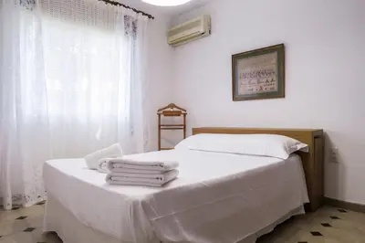 a bedroom with two beds with white sheets and towels at Roche Pinos Verdes in Roche