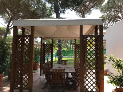 a wooden gazebo with a table and chairs at Roche Pinos Verdes in Roche