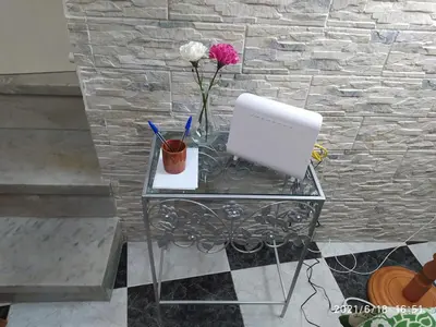 a glass table with a laptop and flowers on it at Los Tres Girasoles in Cádiz