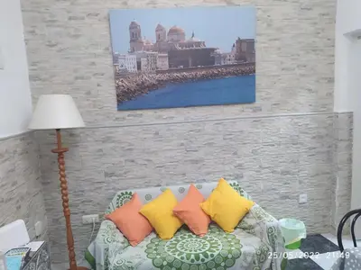 a living room with a couch with colorful pillows at Los Tres Girasoles in Cádiz