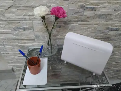 a glass table with a vase of flowers and a computer at Los Tres Girasoles in Cádiz