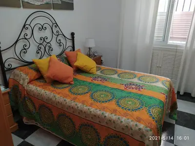a bed with colorful pillows on it in a room at Los Tres Girasoles in Cádiz