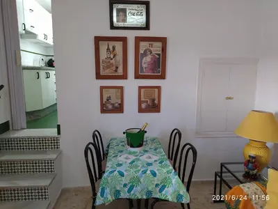 a dining room with a table with chairs and pictures on the wall at Atico Soleado in Cádiz