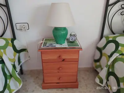 a green lamp on a night stand next to two beds at Atico Soleado in Cádiz