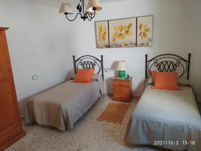 two beds with orange pillows in a bedroom at Atico Soleado in Cádiz