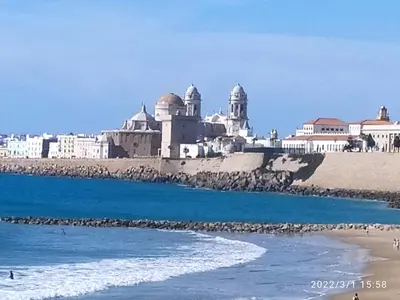 a view of a beach with a building in the background at Atico Soleado in Cádiz