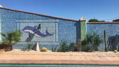 a tile wall with a mosaic of a fish on it at HIGOS CHUMBOS, CASA RURAL COMPARTIDO in Chiclana de la Frontera