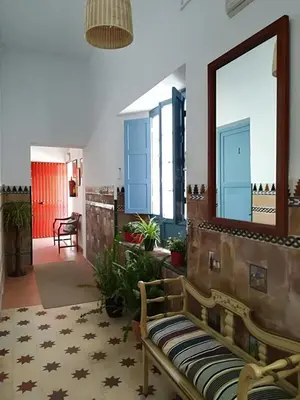 a living room with a bench and a mirror at Tranvía Beach House in Chipiona