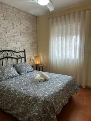 a bedroom with a bed with two towels on it at La Casa del Camaleon in Chipiona