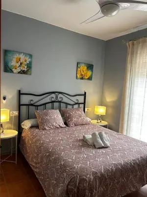a bedroom with a large bed with two pillows at La Casa del Camaleon in Chipiona