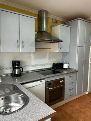 a kitchen with a sink and a stove top oven at La Casa del Camaleon in Chipiona