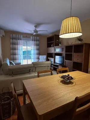 a living room with a table and a couch at La Casa del Camaleon in Chipiona