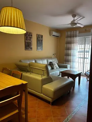 a living room with a couch and a table at La Casa del Camaleon in Chipiona