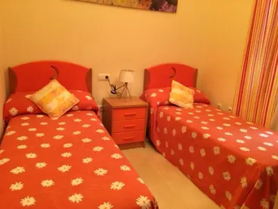 two beds sitting next to each other in a room at Apartamentos Doñana in Sanlúcar de Barrameda