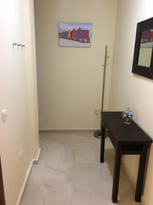 a room with a table and a painting on the wall at Apartamentos Doñana in Sanlúcar de Barrameda