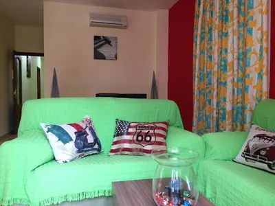 a living room with a green couch and a table at Apartamentos Doñana in Sanlúcar de Barrameda