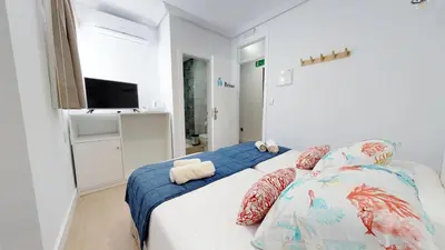 a bedroom with a bed with pillows and a television at Hostal Boutique La Española in Rota