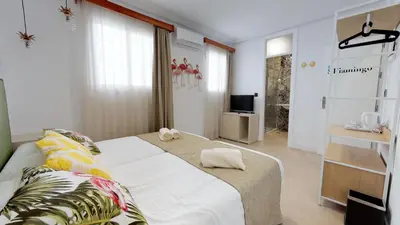 a bedroom with a large bed and a television at Hostal Boutique La Española in Rota