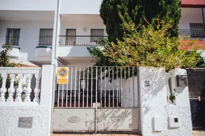 a white gate in front of a white house at Casa Cordoba in Chipiona