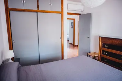 a bedroom with a blue bed and a dresser and a mirror at Casa Cordoba in Chipiona