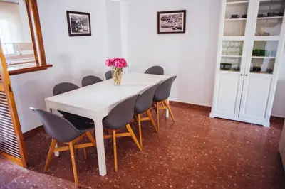 a white table with chairs and a vase of flowers on it at Casa Cordoba in Chipiona