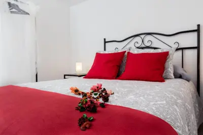 a red bed with red pillows and a red blanket at Catedral Cadiz in Cádiz