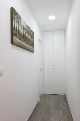 a hallway with white walls and a painting on the wall at Catedral Cadiz in Cádiz