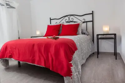 a bedroom with a red bed with red pillows at Catedral Cadiz in Cádiz