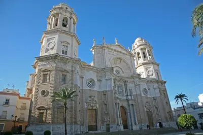 a church with two towers and palm trees in front at Catedral Cadiz in Cádiz