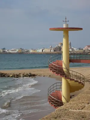 a yellow staircase on a beach with the ocean at Botic4 in Cádiz