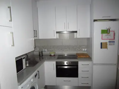 a white kitchen with a stove and a refrigerator at Botic4 in Cádiz