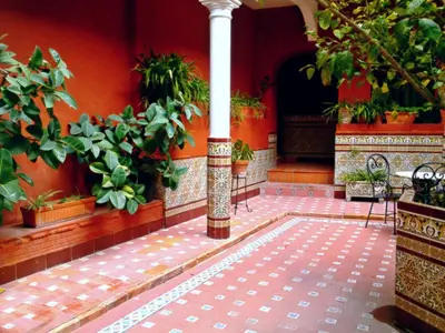 a courtyard with potted plants and a column in a building at Al Andalus Jerez in Jerez de la Frontera