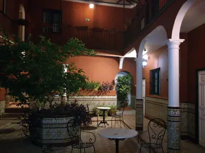 a courtyard with tables and chairs and a tree at Al Andalus Jerez in Jerez de la Frontera