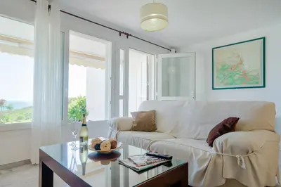 a living room with a white couch and a glass table at Casas Fuente del Sol in Conil de la Frontera