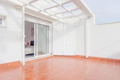 a small bedroom with a bed and a red dresser at Casas Fuente del Sol in Conil de la Frontera